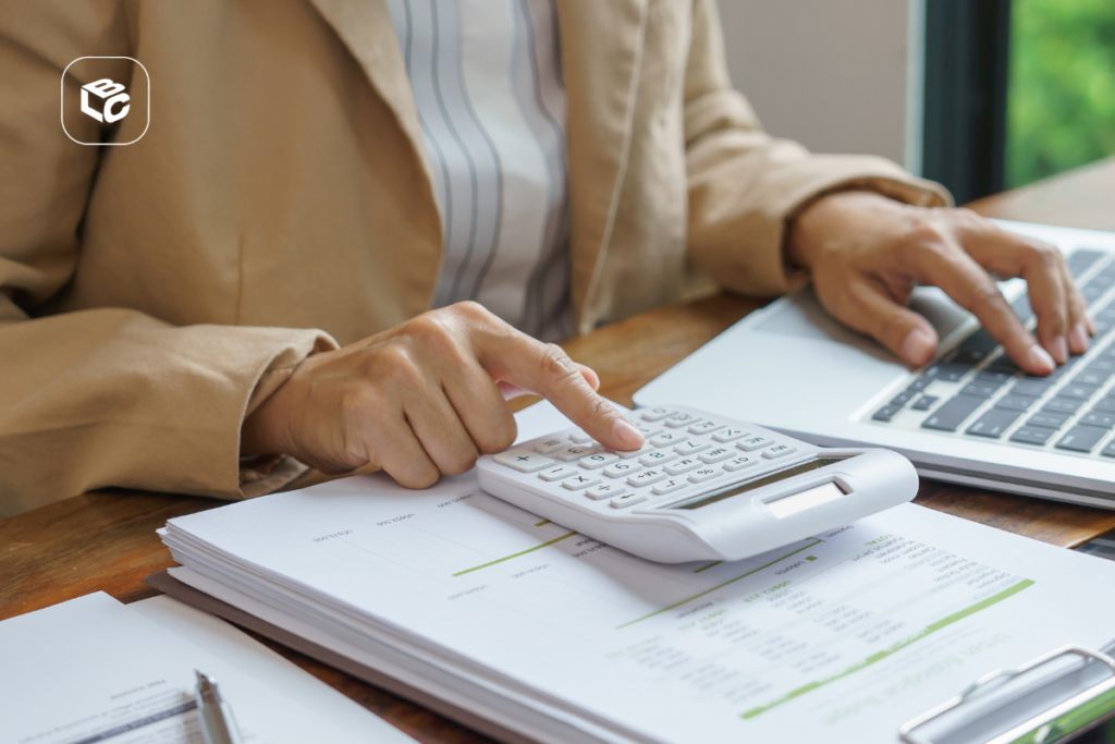 Pessoa usando calculadora e laptop para gerenciar precatório federal de servidor público